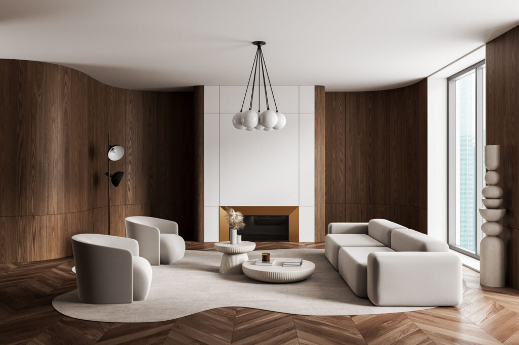 A modern living room with curved wooden walls, a white fireplace, a sectional sofa, two armchairs, and a large window.