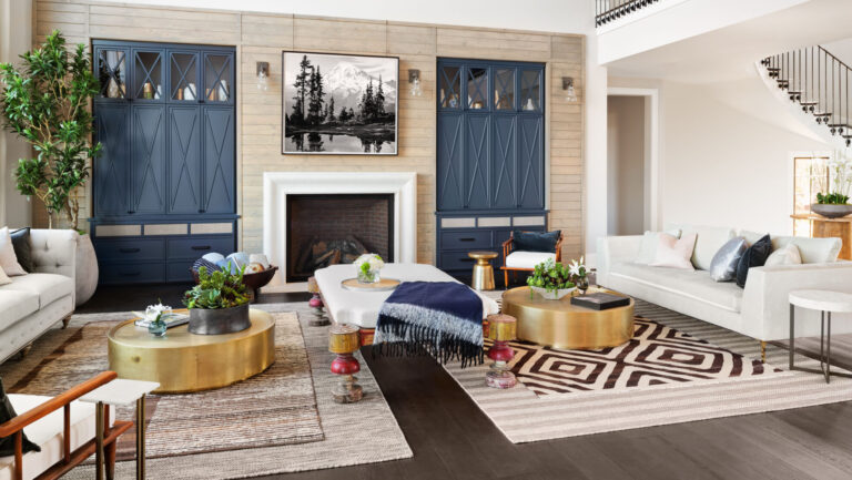 Beautiful Spacious Living Room in Luxury Home with Loft, Elegant Chandelier, and Hint of Spiral Staircase. Has Fireplace, Hardwood Floors, and Tall Ceiling.